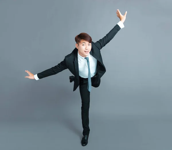 Šťastný mladý obchodník tančí v pohybu — Stock fotografie