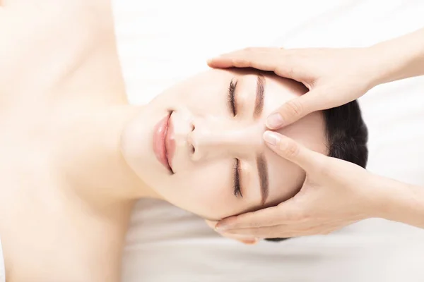 Closed young woman face and head massage in spa — Stock Photo, Image