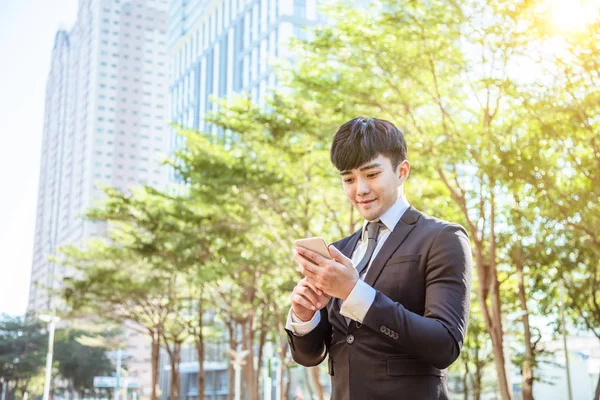 Ασιατικές νεαρός επιχειρηματίας χρησιμοποιώντας το κινητό τηλέφωνο — Φωτογραφία Αρχείου