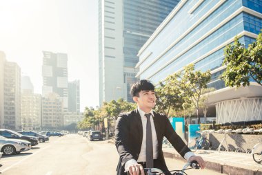 İş adamı sabah işe bisikletle gidiyor.