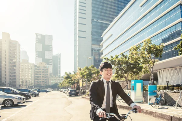 Homme d'affaires à vélo pour travailler dans la rue urbaine le matin — Photo