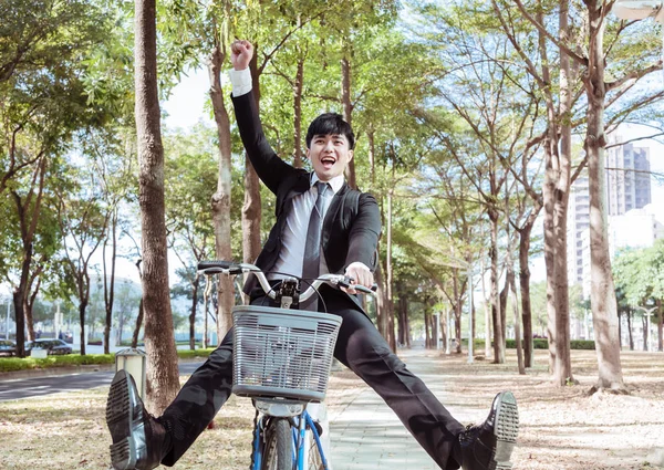 Счастливый бизнесмен езда на велосипеде на работу на городской улице — стоковое фото