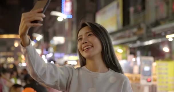 夜市でスマートフォンを使って幸せな若いアジアの女性 — ストック動画