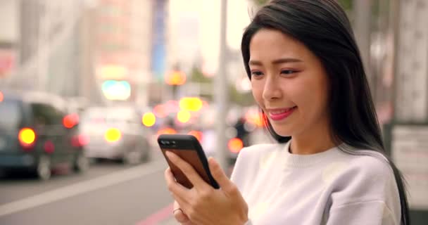 夜市内でスマートフォンを見ている若い女性 — ストック動画