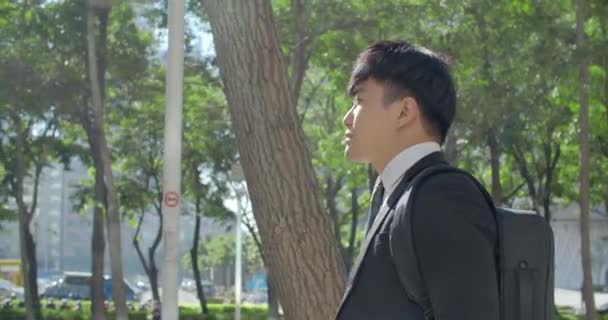 若いビジネスマンがオフィスまで通りを歩いていく — ストック動画