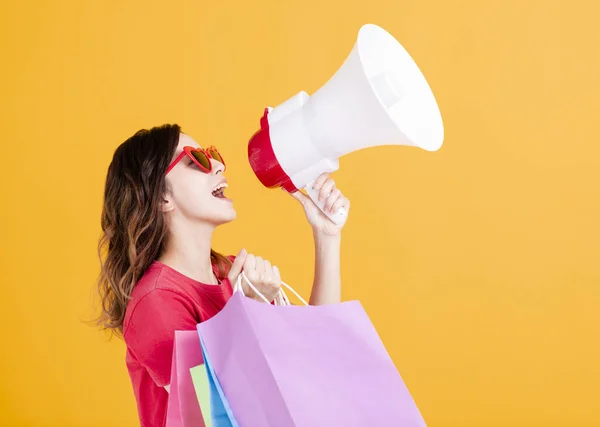 Feliz joven Mujeres sosteniendo bolsas de compras y megáfono — Foto de Stock