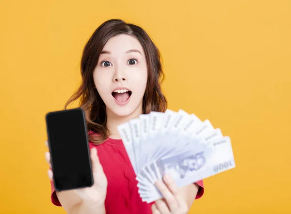 Surprised young woman holding mobile phone and money. — 스톡 사진