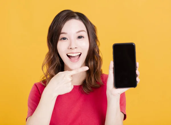 Heureuse jeune femme montrant le téléphone intelligent — Photo