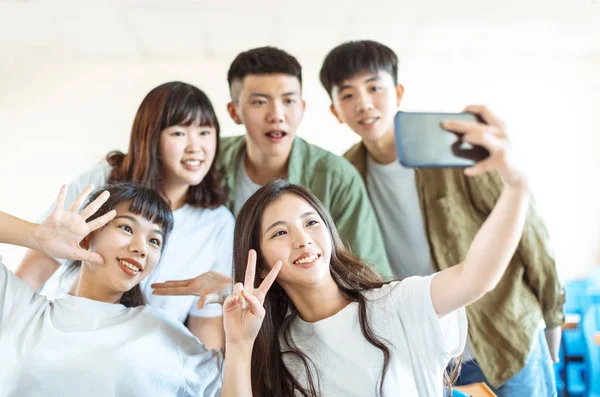 Jovem grupo feliz de adolescentes fazendo selfie divertido na sala de aula — Fotografia de Stock