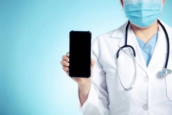 Steteskoplu bir doktor ve tıbbi muayene için elinde akıllı telefon var. — Stok fotoğraf