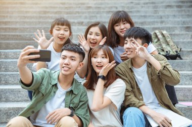 Group of students taking selfie on the stairs  at campus