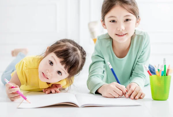 Mutlu Iki Küçük Kız Çiziyor Üzerinde Ödev Yapıyor — Stok fotoğraf