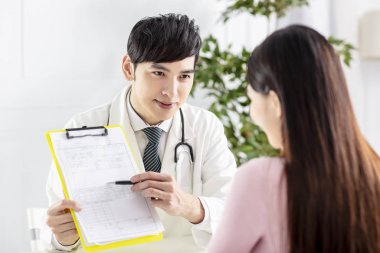 Doktor hastasına tıbbi raporları açıklıyor.