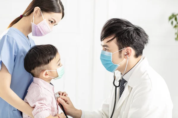 Arzt Trägt Maske Und Untersucht Kleinen Jungen Klinik — Stockfoto