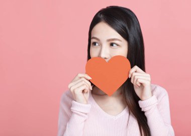 Kırmızı kağıt kalpler tutan ve sevgililer gününü kutlayan mutlu genç bir kadın.