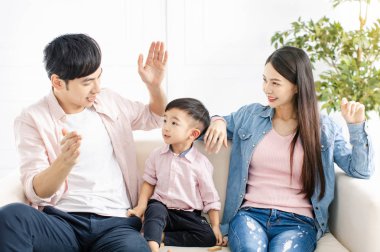 Baba oğluyla oturma odasındaki kanepede konuşuyor.