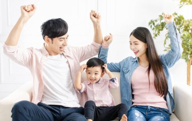 Mutlu aile oynuyor ve oturma odasındaki kanepede oturuyor.