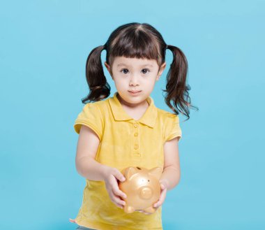 Güzel, mutlu bir bebek kumbara tutuyor. 