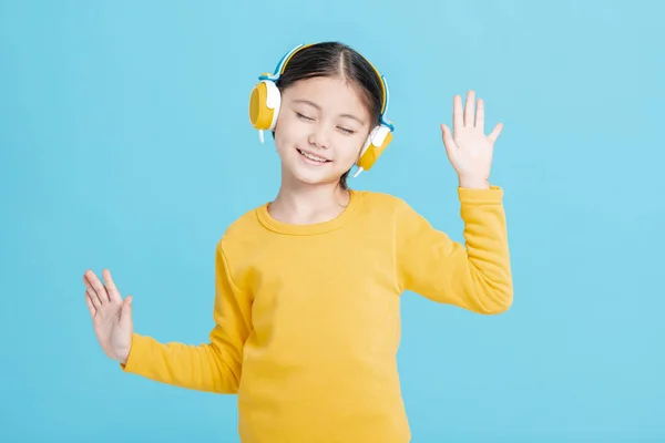 快乐的小女孩在耳机里听音乐 — 图库照片