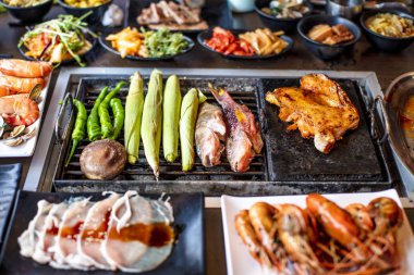 Restoranda ızgarada ızgara tavuk ve deniz ürünleri.