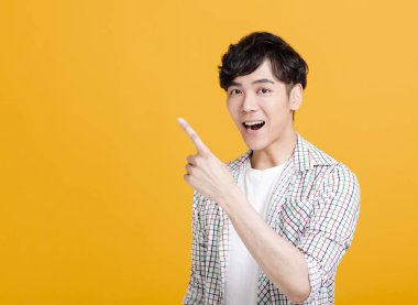  Mutlu genç adam bir şeyi işaret ediyor.