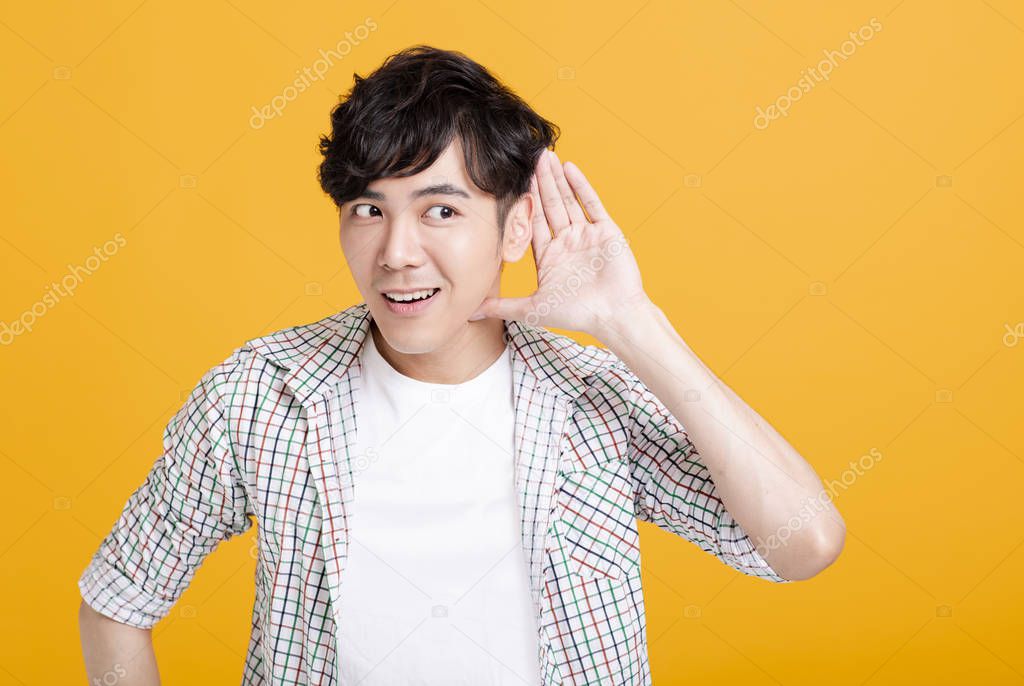 young man  with hand over ear listening and hearing