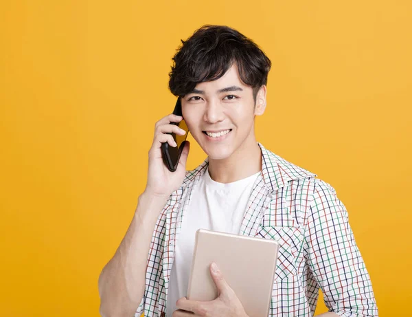 smiling young  man with mobile phone and tablet
