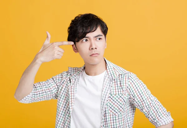 Unge Man Pekar Finger Huvudet — Stockfoto