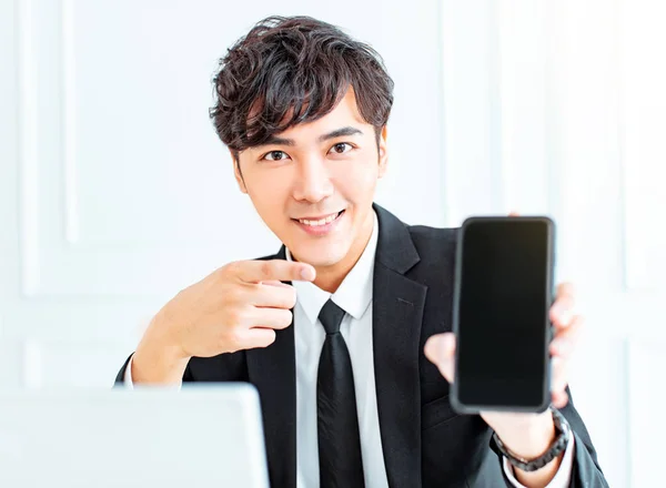Νεαρός Επιχειρηματίας Δείχνει Έξυπνο Τηλέφωνο Στο Γραφείο — Φωτογραφία Αρχείου