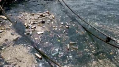 Plastik şişeler, torbalar, suda yüzen atıklar. Deniz suyu kirliliği kavramı. Plastik kirliliği krizi