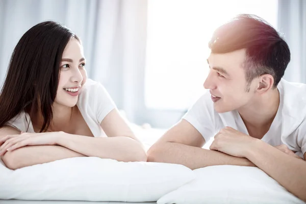 Feliz Jovem Casal Olhando Para Outro Sorrindo Enquanto Deitado Cama — Fotografia de Stock