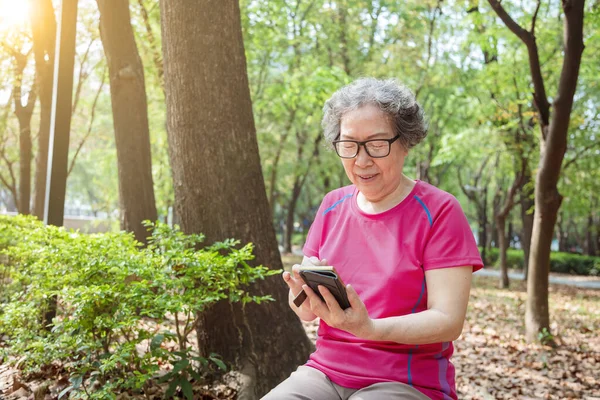 Azjatycki Starszy Kobieta Okulary Czytanie Telefon Komórkowy — Zdjęcie stockowe