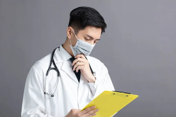 Joven Médico Desgaste Máscara Médica Mirando Informe Del Examen —  Fotos de Stock