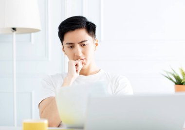 Genç adam evde çalışıyor ve veri okuyor. 