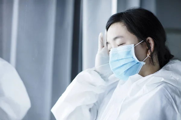 Κουρασμένη Γυναίκα Γιατρός Προστατευτική Στολή Και Κοιτάζοντας Μέσα Από Παράθυρο — Φωτογραφία Αρχείου