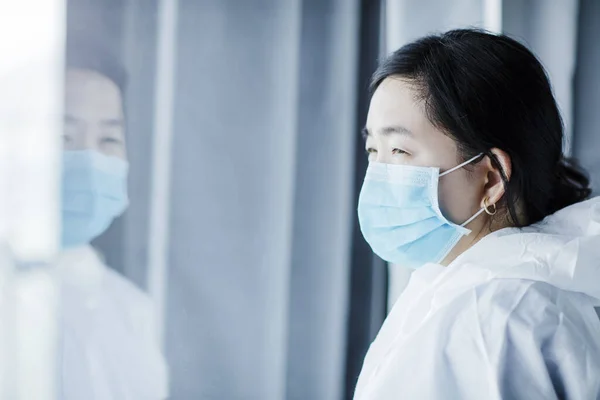 Asiática Médica Feminina Terno Protetor Olhando Através Janela Hospital — Fotografia de Stock