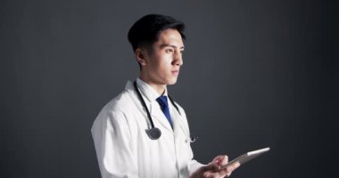 Genç erkek doktor tablet dijital bilgisayar kullanıyor.