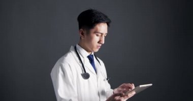 Genç erkek doktor tablet dijital bilgisayar kullanıyor.