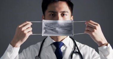 Asyalı genç doktor tıbbi maske takıyor. 