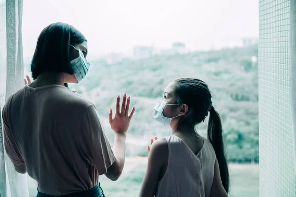 Moeder Met Dochter Kind Masker Kijken Uit Raam — Stockfoto