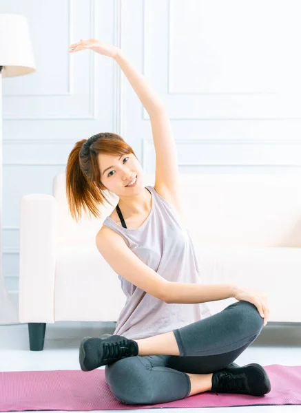 在客厅里练习瑜伽的年轻女人 — 图库照片