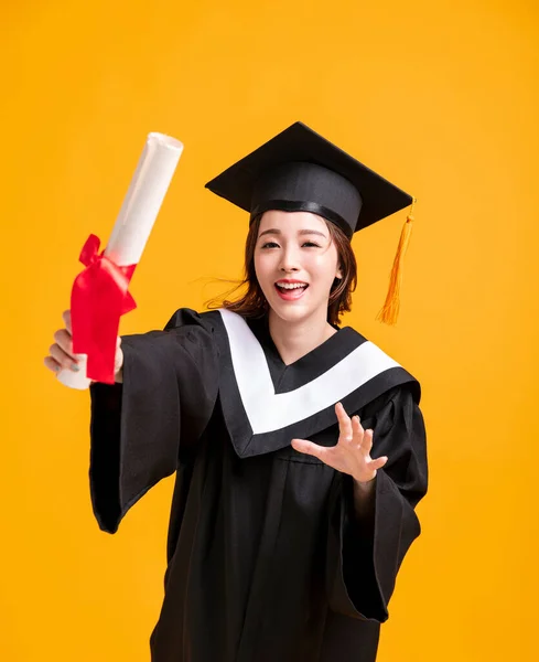 Mezuniyet Elbisesi Içinde Diplomasını Gösteren Mutlu Genç Bir Kadın — Stok fotoğraf