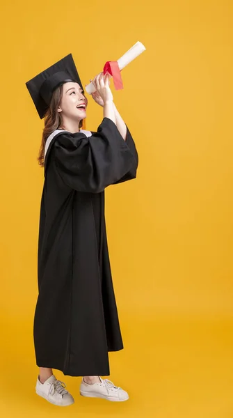 Glad Ung Kvinna Examen Klänningar Och Tittar Igenom Diplom — Stockfoto