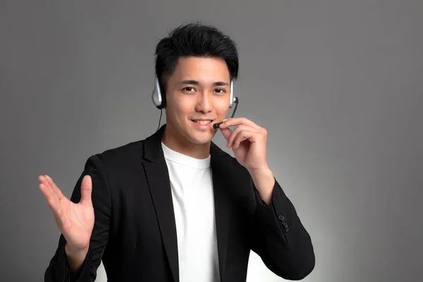 Smiling Young Asian Businessman Talking Headset Gray Background — Stock Photo, Image