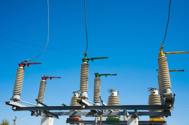 Mavi gökyüzü arka planında yüksek voltajlı güç transformatörü.