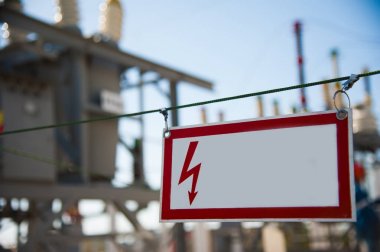 Elektriksel tehlike işareti metal bir çite yerleştirilmiş.
