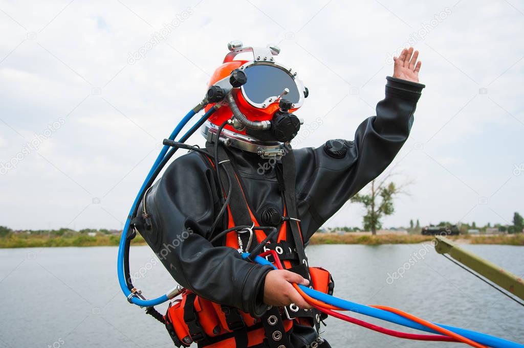 Diver in the water in a diving suit and helmet ready to dive