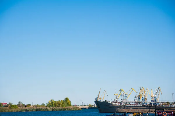Limanda yükleniyor. Mavi gökyüzü arka planda yüzen liman vinç — Stok fotoğraf