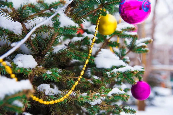 Kerstboom met decoratie onder sneeuw — Stockfoto