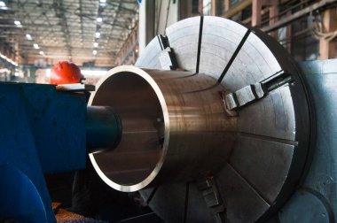İşçi endüstriyel metalcilik için bir makinede metal işliyor. Sanayi